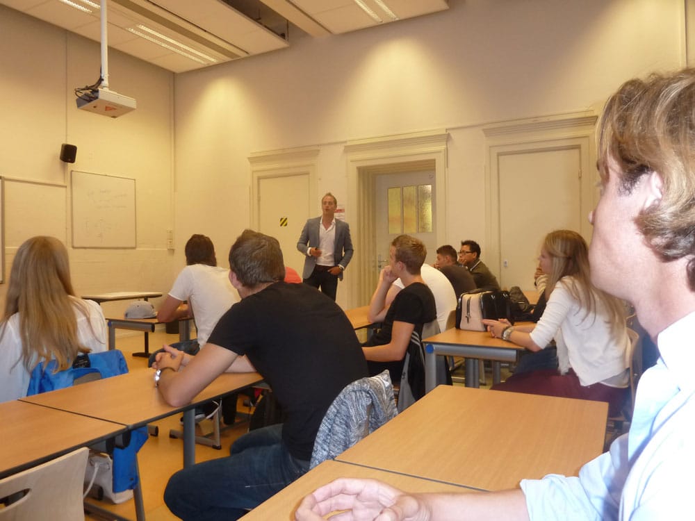 a man standing in front of a group of people in a classroom